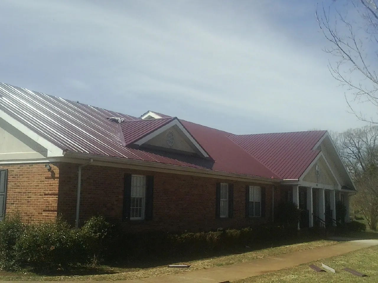 Red metal roof with gabled entries on a long brick building in Rocky Mount