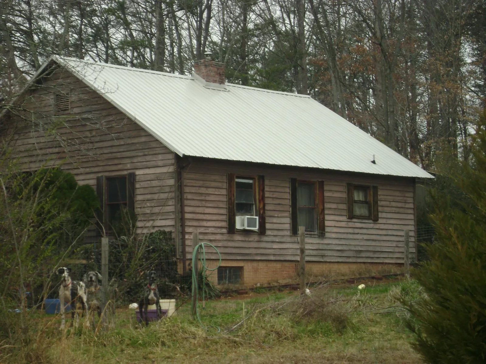 White metal roof on an old wood sided farmhouse, from a Metal Roof Installation job in Rocky Mount
